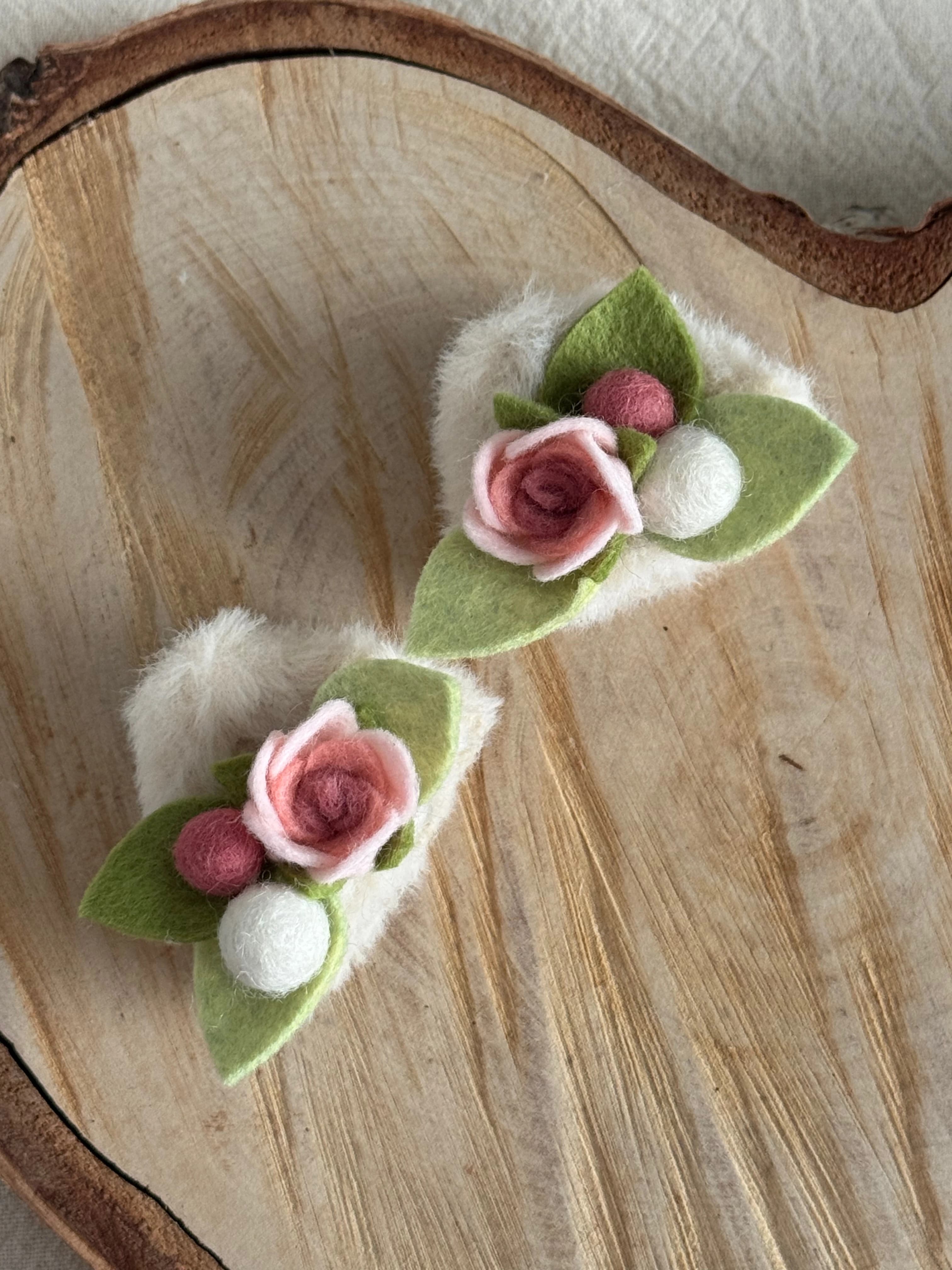 Cream and pink rose cat-ear clips viewed from above