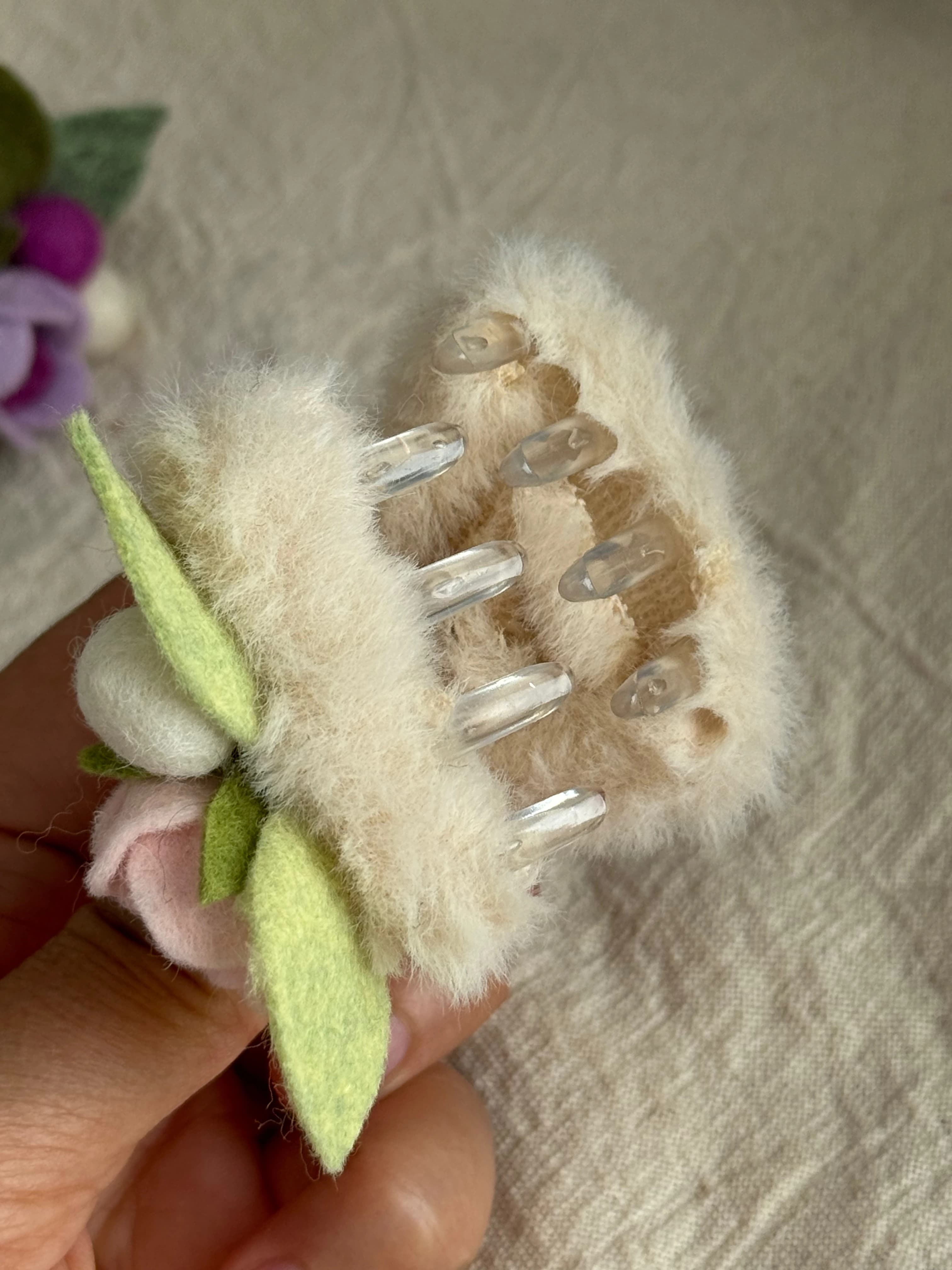 Claw fastening beneath the cream and pink rose cat-ear clip
