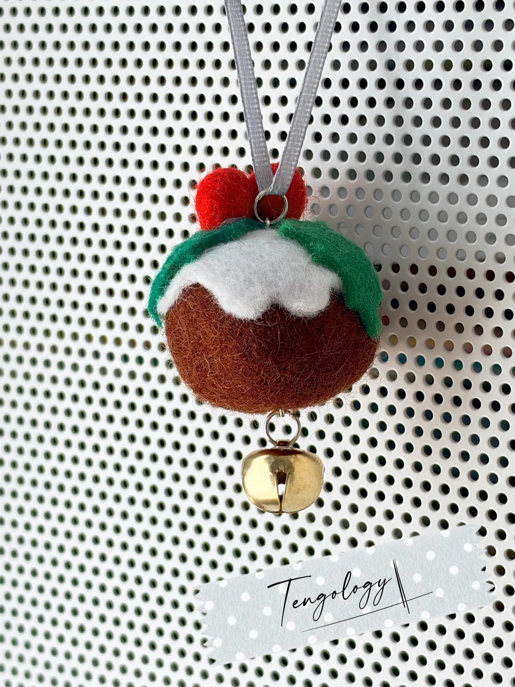The back of the felt Christmas pudding ornament, showing the silver ribbon loop, custard topping and holly