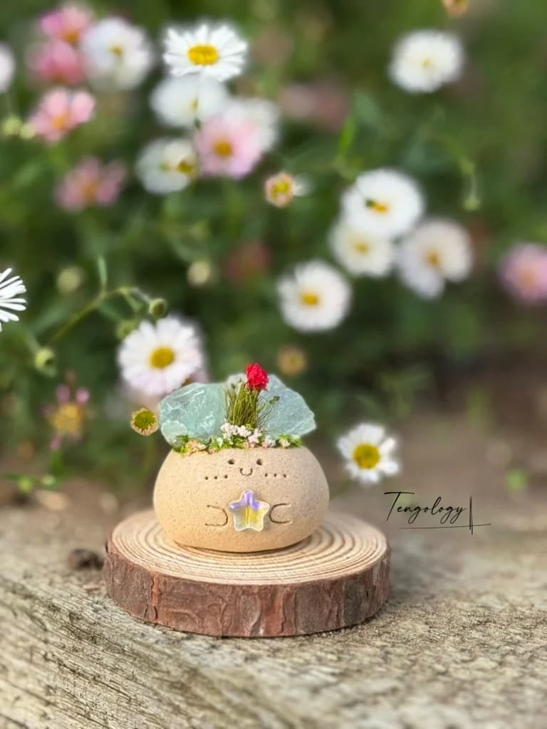 A Crysprout with sea-green fluorite and a red dried flower