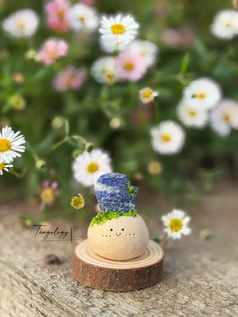 A small Crysprout wearing deep blue lapis on a moss tuft