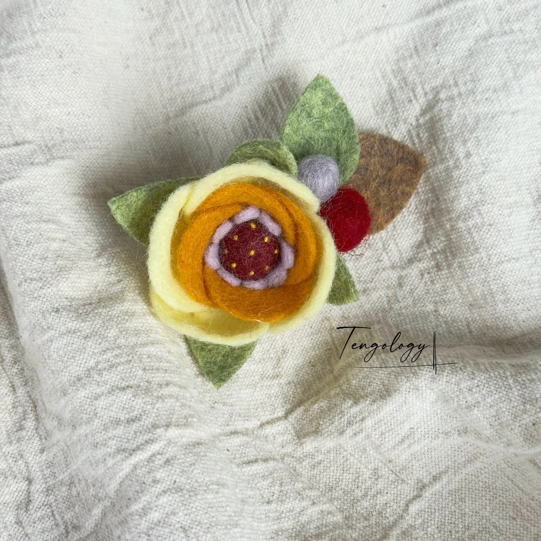 Layered felt flower brooch — Pale yellow / ochre, front