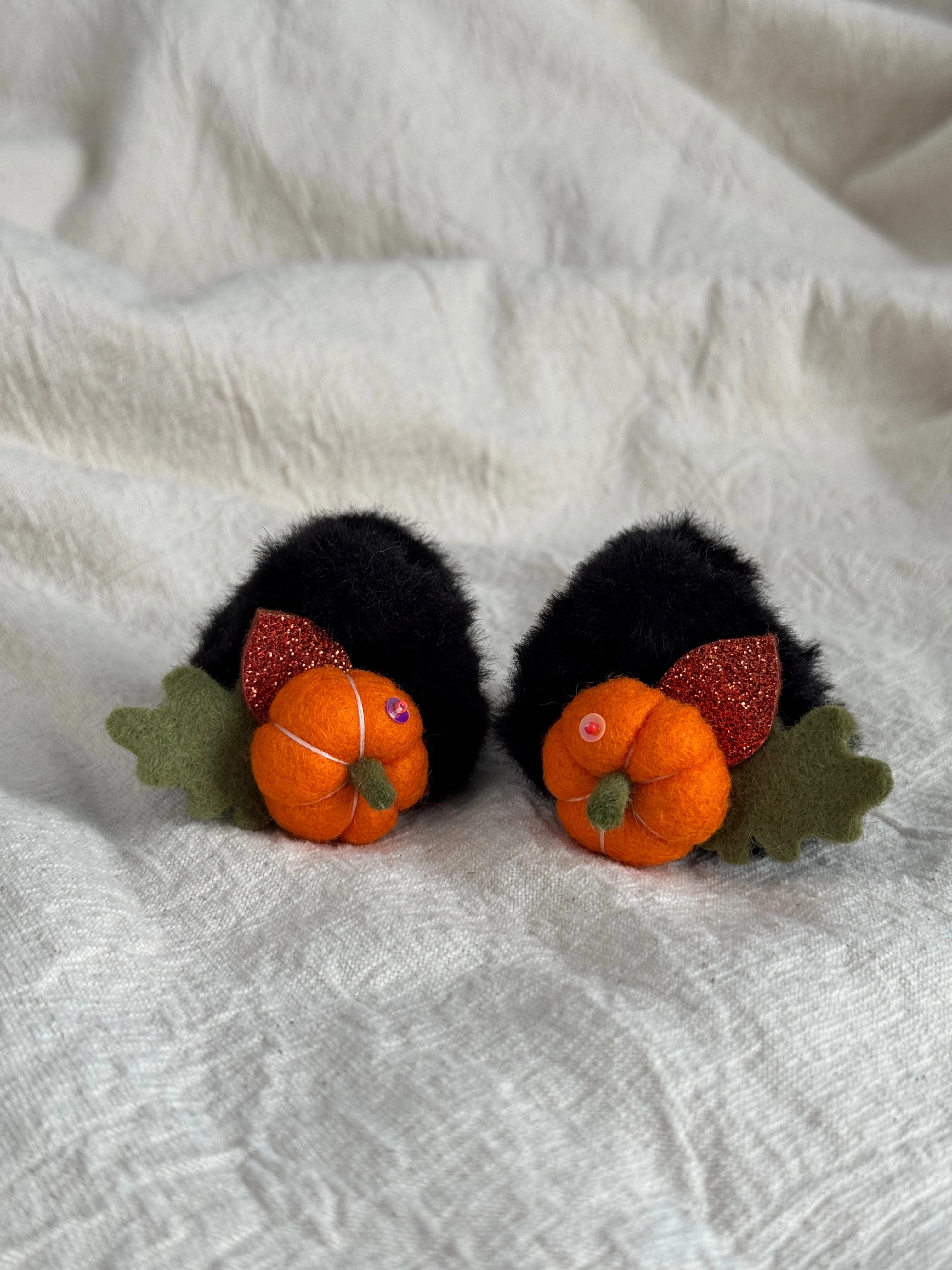 Pair of black faux-fur mini claw clips with orange felt pumpkins and autumn leaves