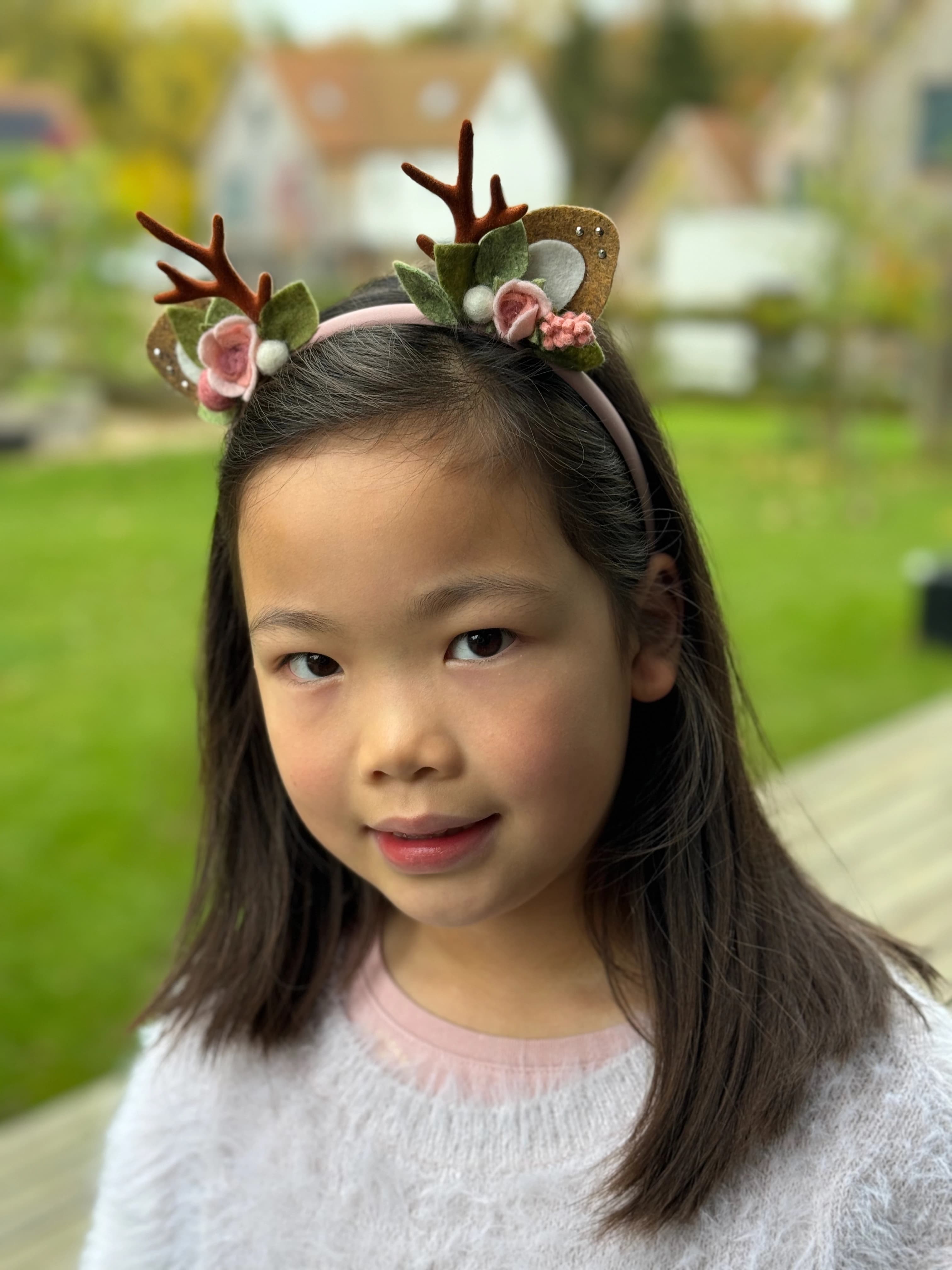 Blush / pink reindeer antler and rose headband worn by a customer