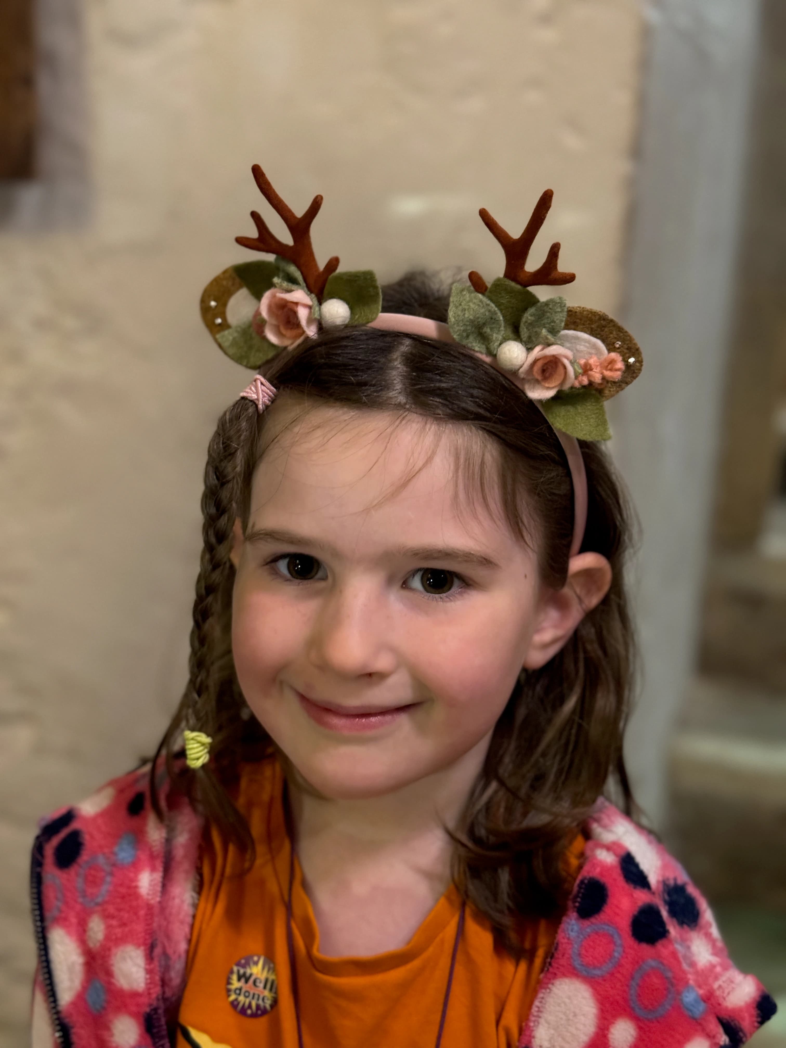 Blush / pink reindeer antler and rose headband worn by a customer