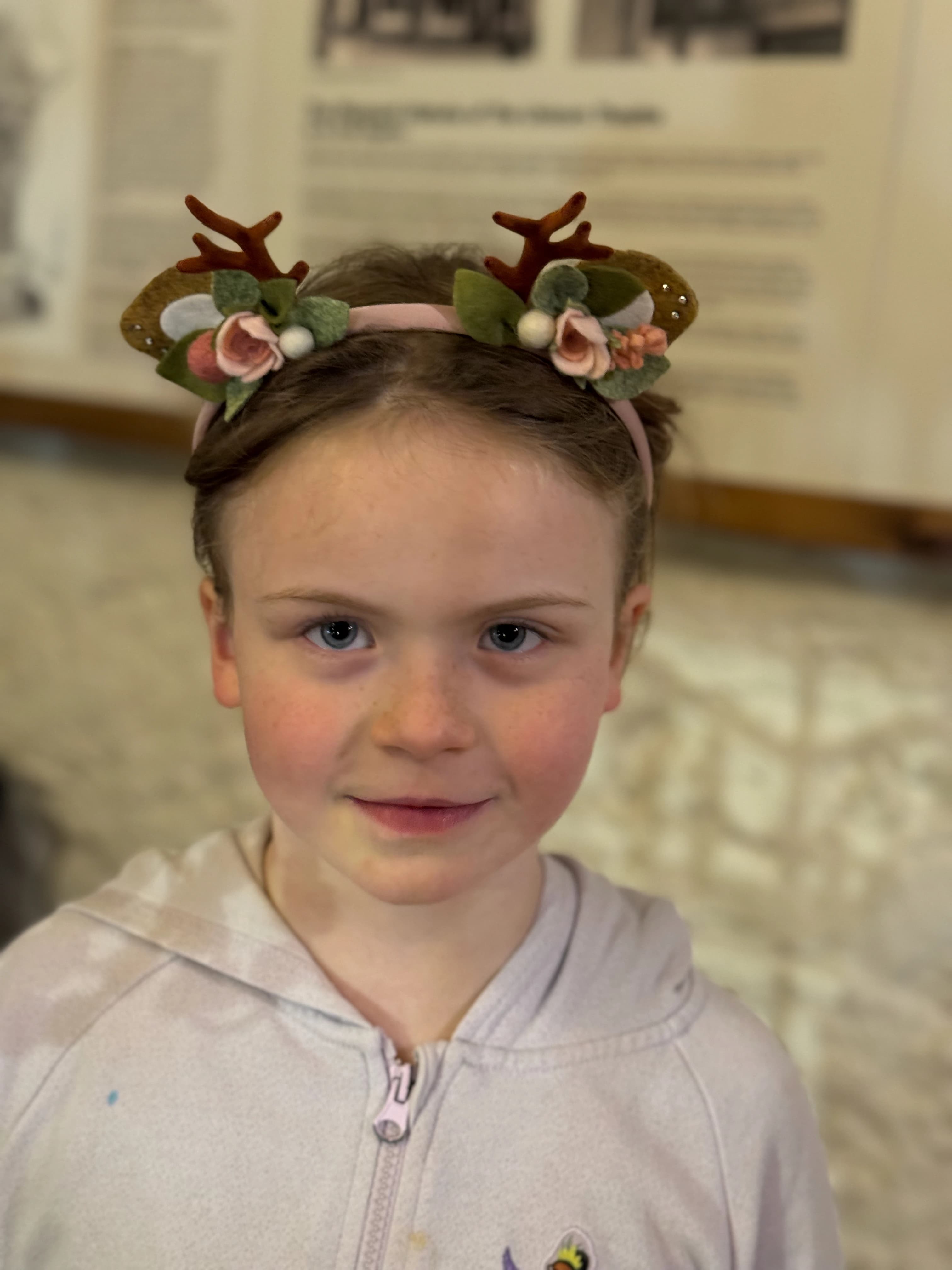 Blush / pink reindeer antler and rose headband worn by a customer