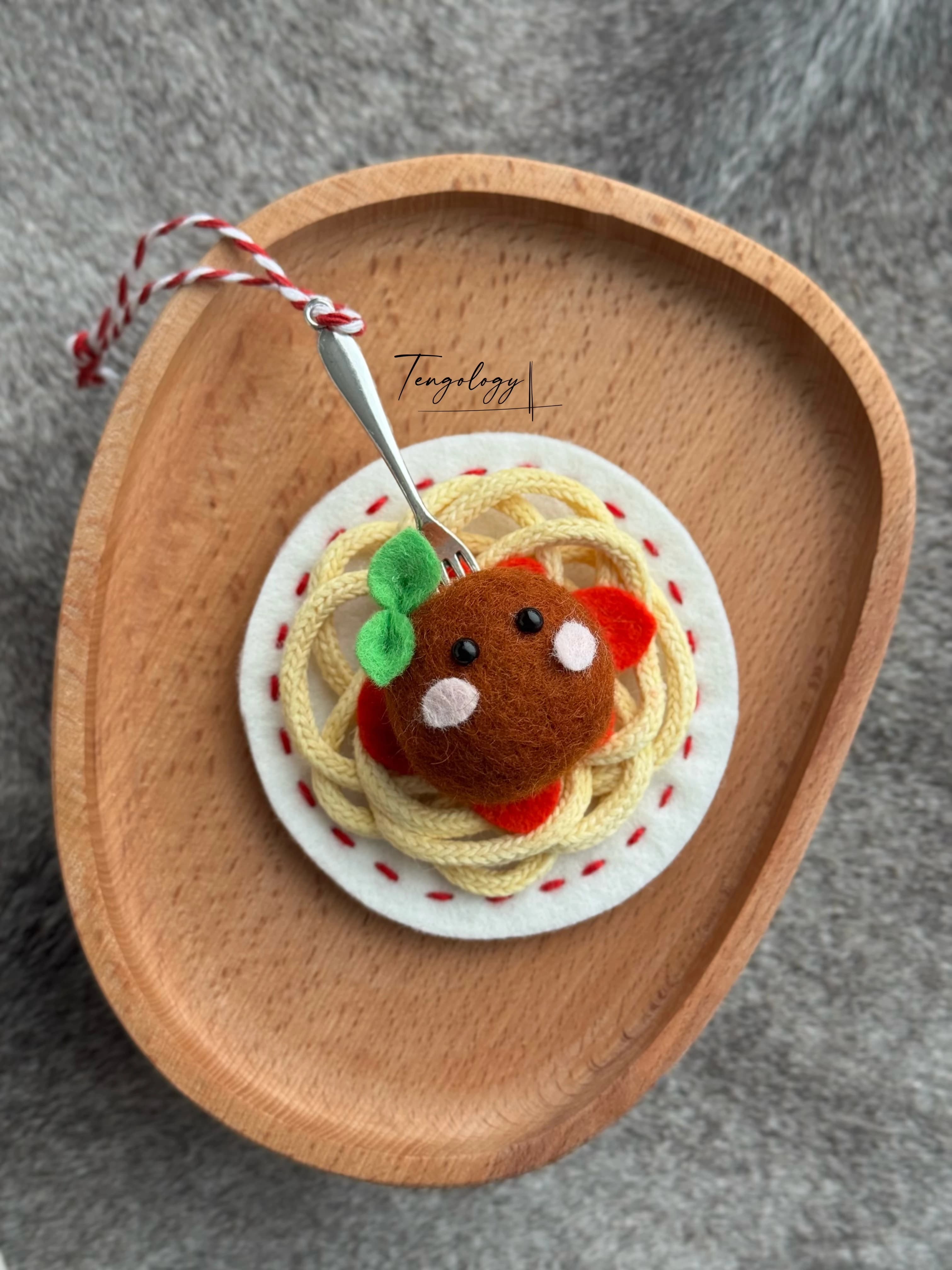 Spaghetti and meatball felt ornament with red stitching around the plate