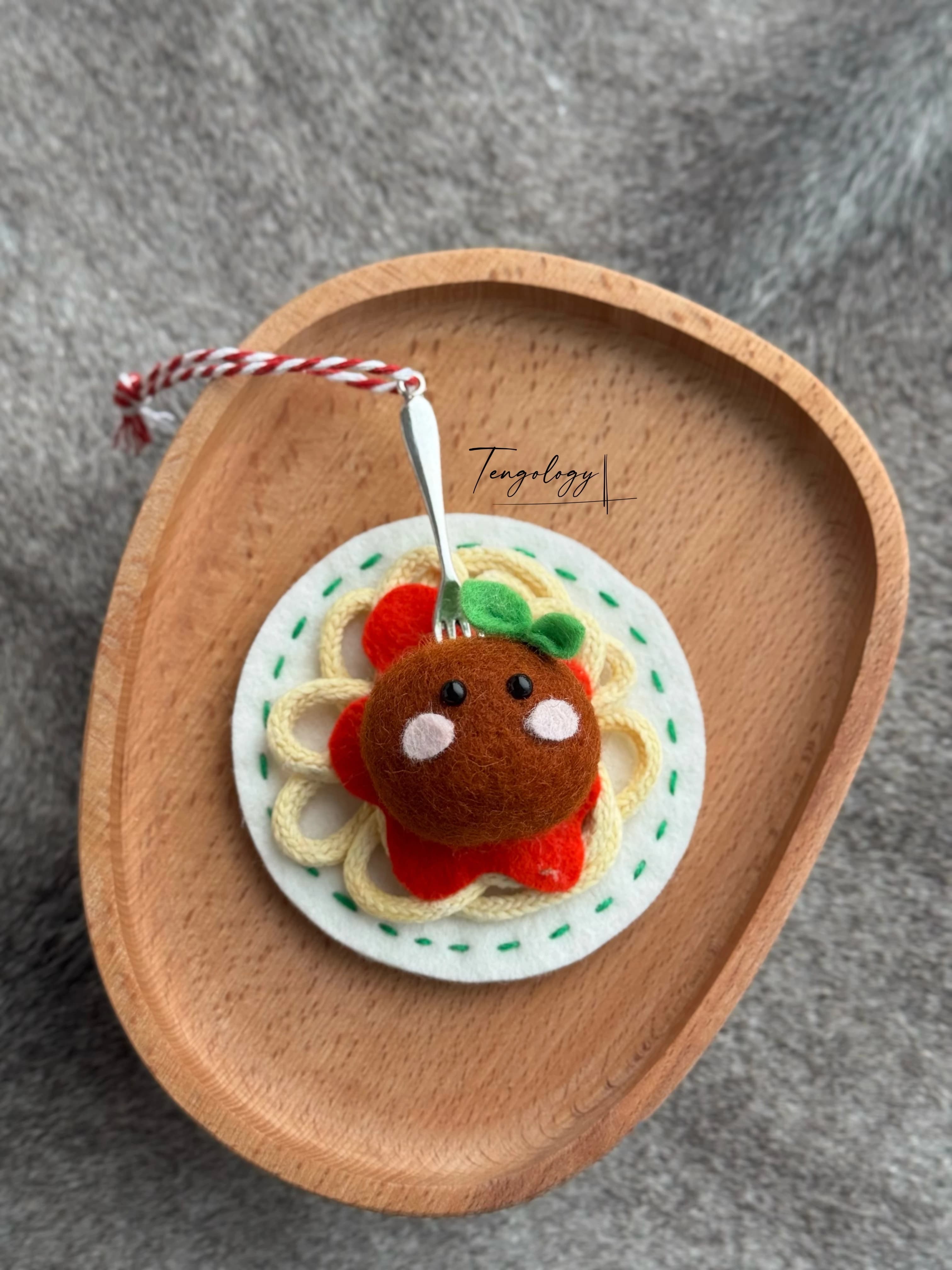 Spaghetti and meatball felt ornament with green stitching around the plate