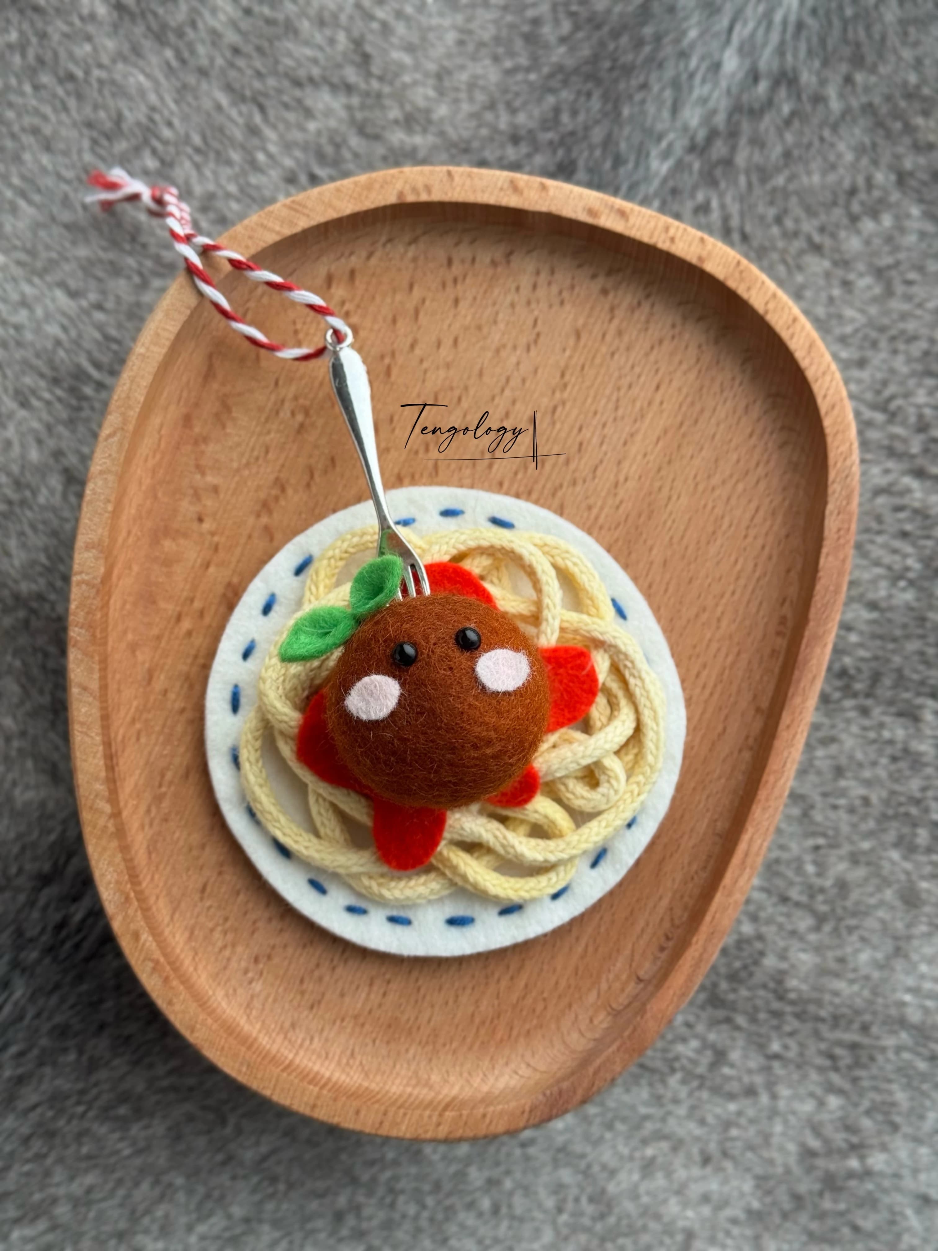 Spaghetti and meatball felt ornament with blue stitching around the plate