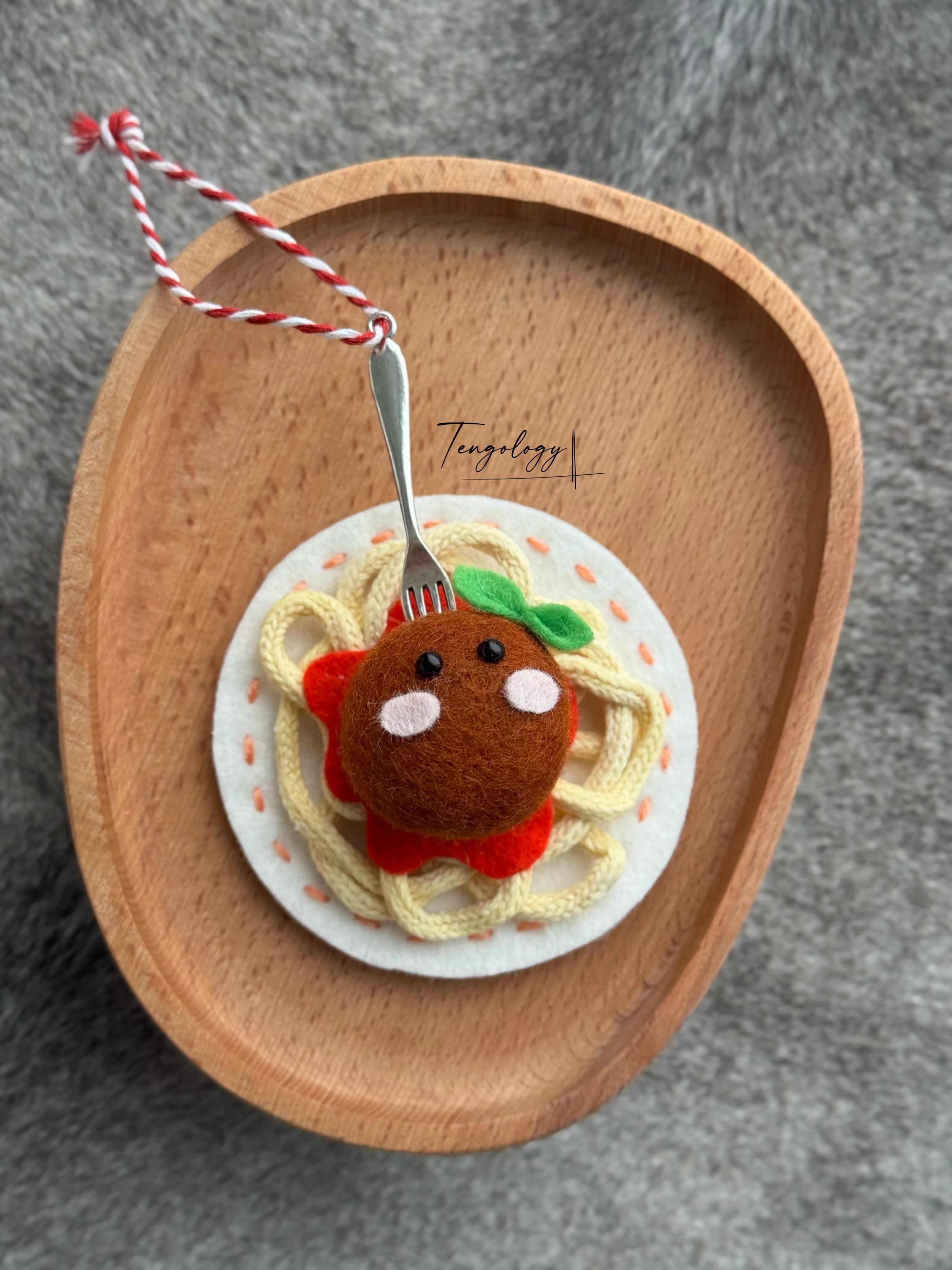 Spaghetti and meatball felt ornament with peach stitching around the plate