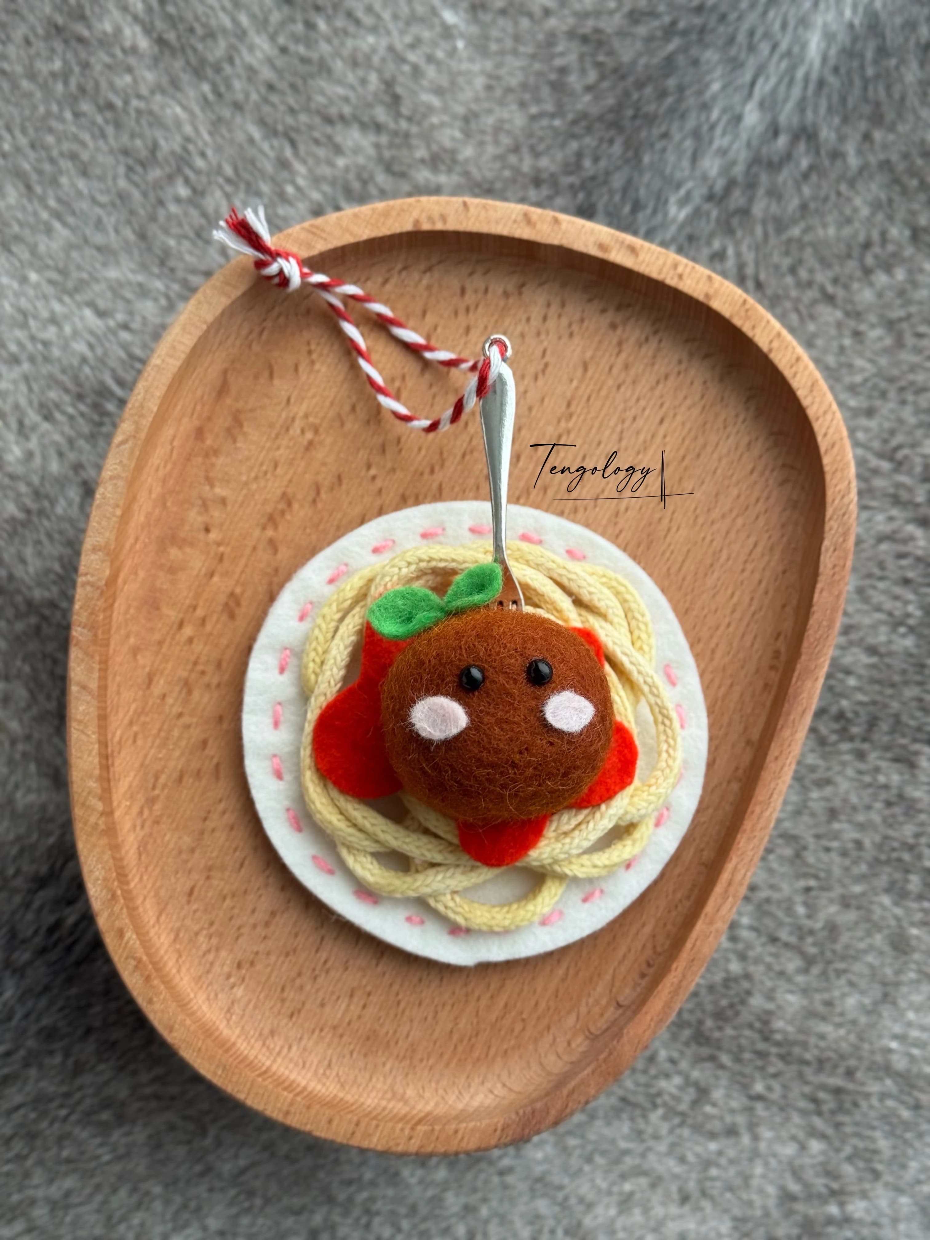Spaghetti and meatball felt ornament with pink stitching around the plate